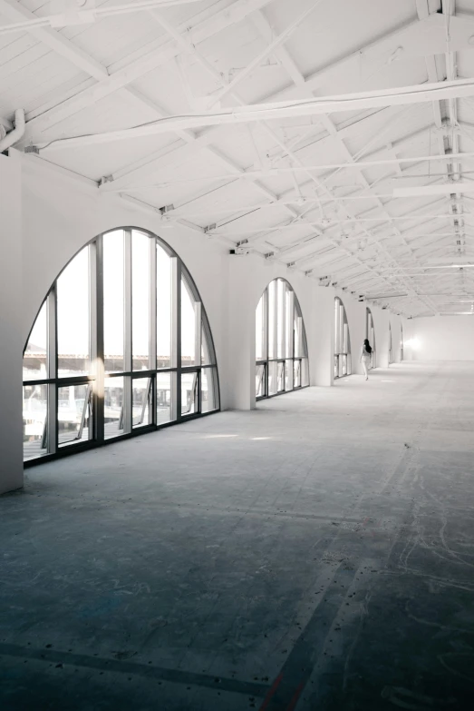 an empty room with windows and a person walking