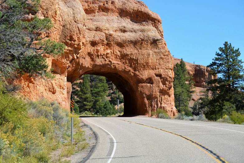 a car drives through a tunnel in the middle of the road