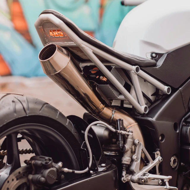 the front end of a white motorcycle parked in front of graffiti