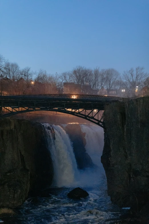 the bridge has a small waterfall at the base