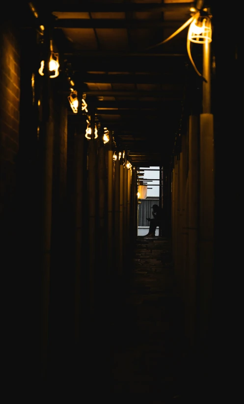 an aisle that is empty with several lights hanging from the end of it