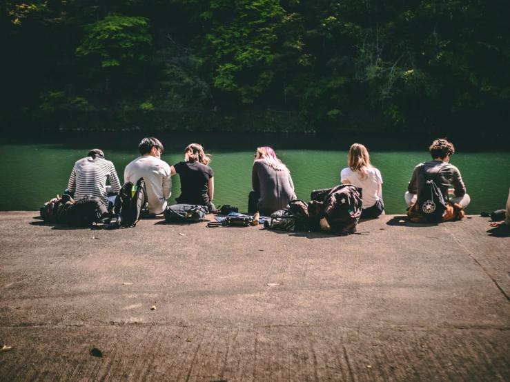 a group of people with suitcases at the water's edge