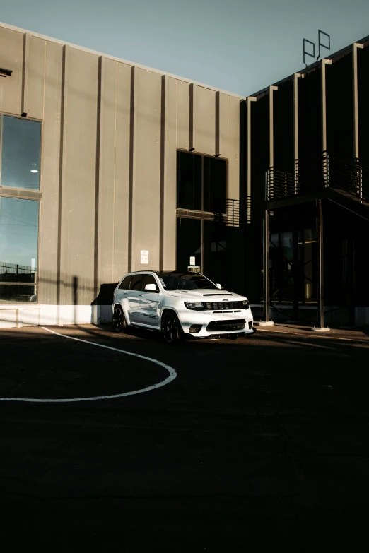 white car parked in front of a building with a parking meter