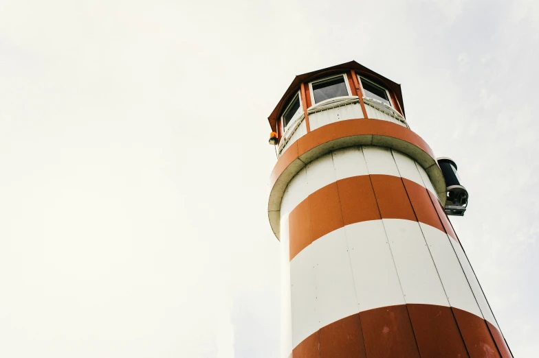 a large red and white light house standing on top of a hill