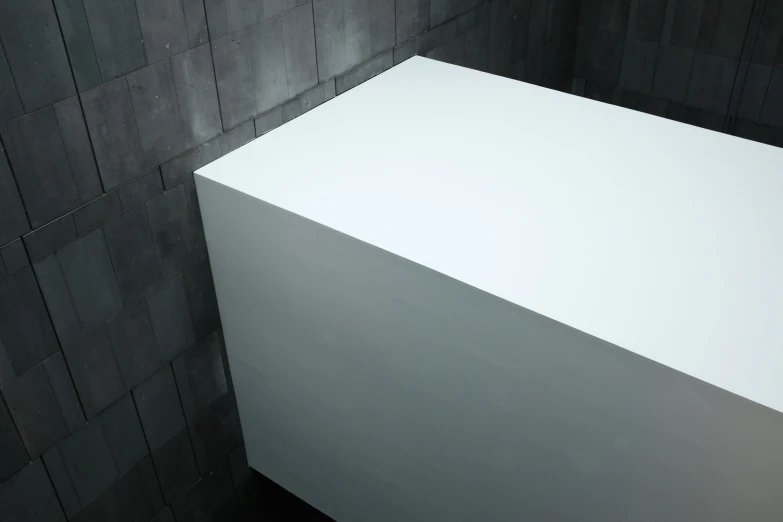 a white counter in front of a grey wall