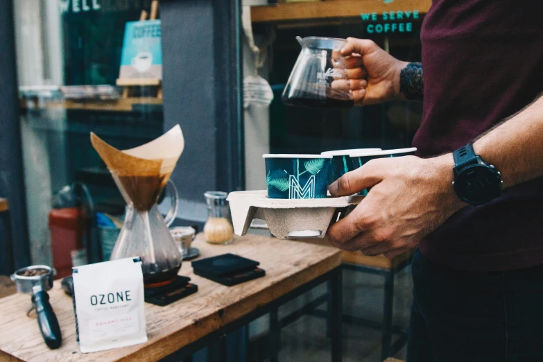 person is filling a cup with some kind of beverage