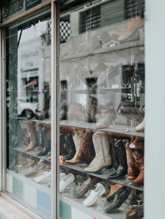 a glass window that shows several pairs of shoes on display