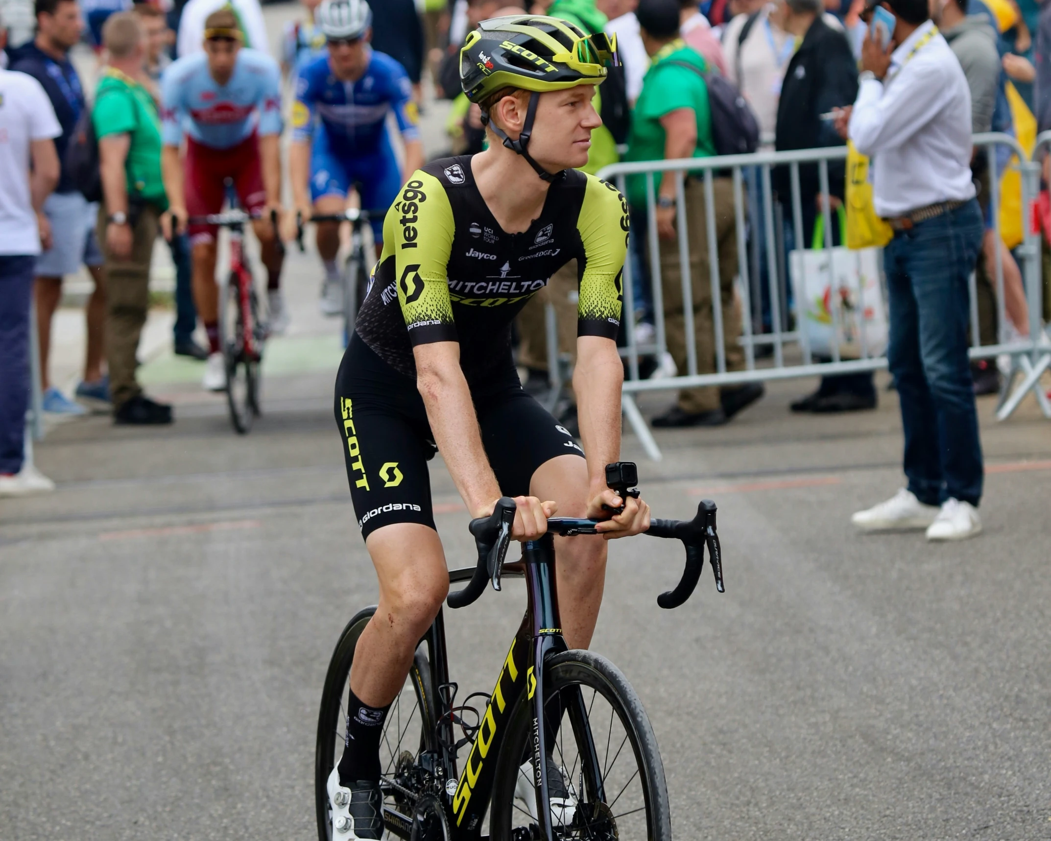 a bicyclist in a bike race with a crowd watching