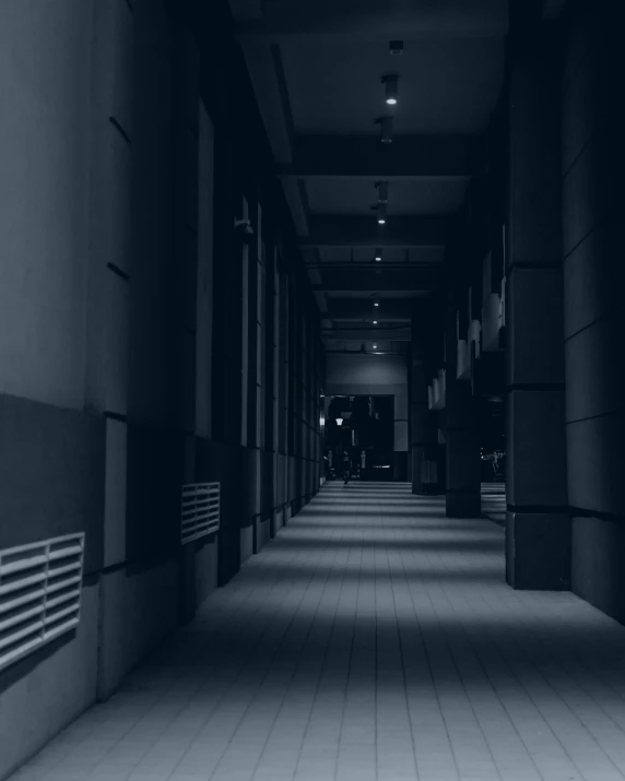 dark building with very long hallway lined with light