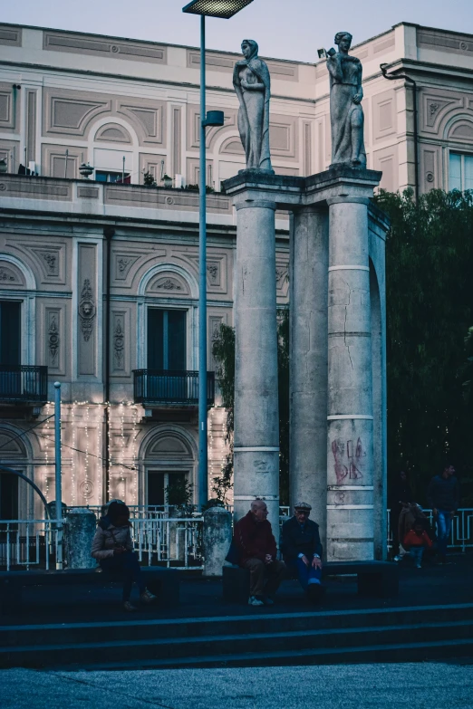 a statue of two men is sitting in the front yard of an old building