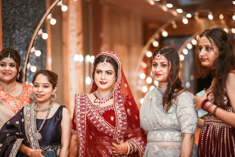 the bride poses for a group po with other bridals