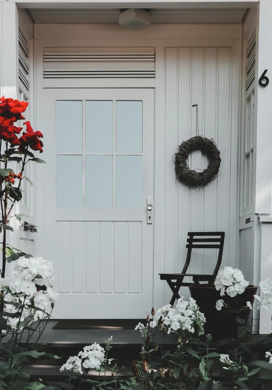 a wooden chair sitting in front of a white door