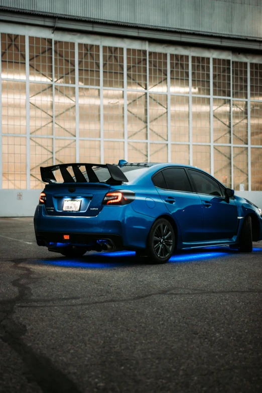the blue sport car with its trunk strapped to the rear of it