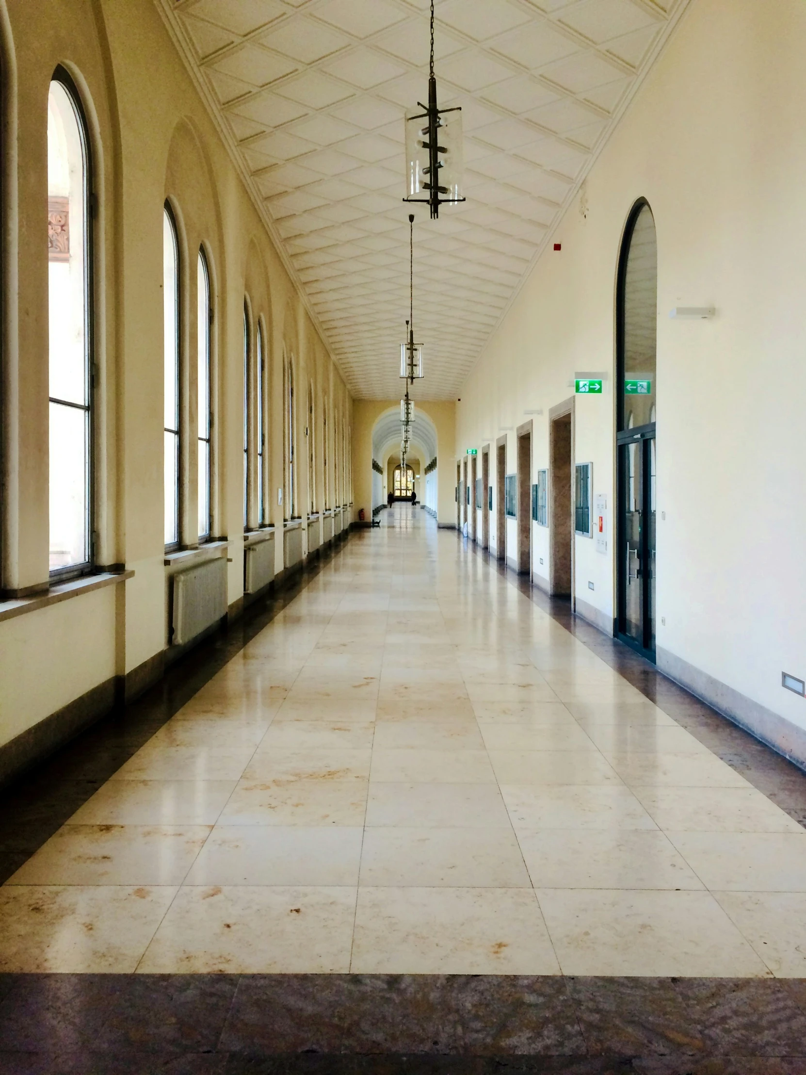 a hallway in an old building has two door elevators