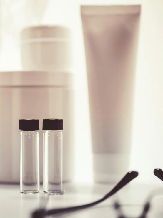 three glasses are sitting next to a jar