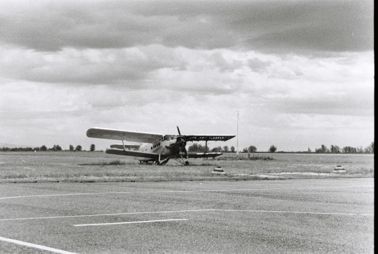 an old fashioned propeller plane sitting on top of a field