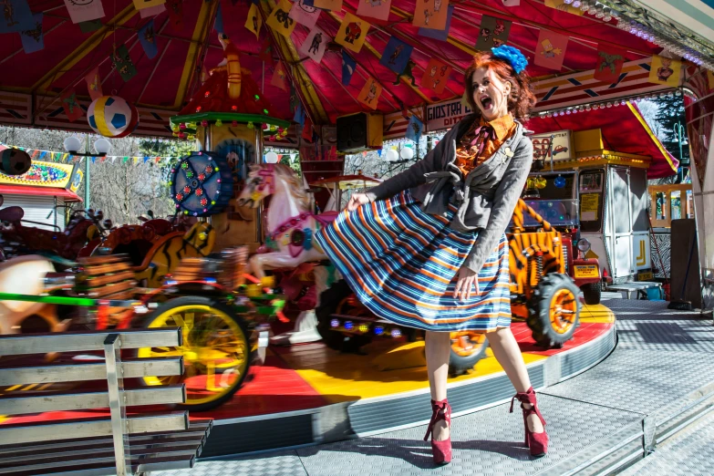 an orange haired woman standing next to a carousel