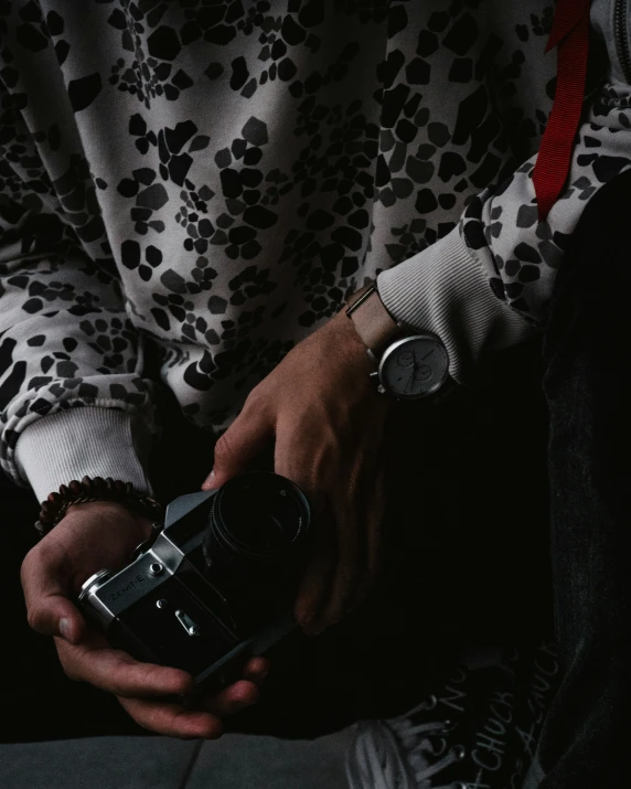 man holding and adjusting his camera in the dark