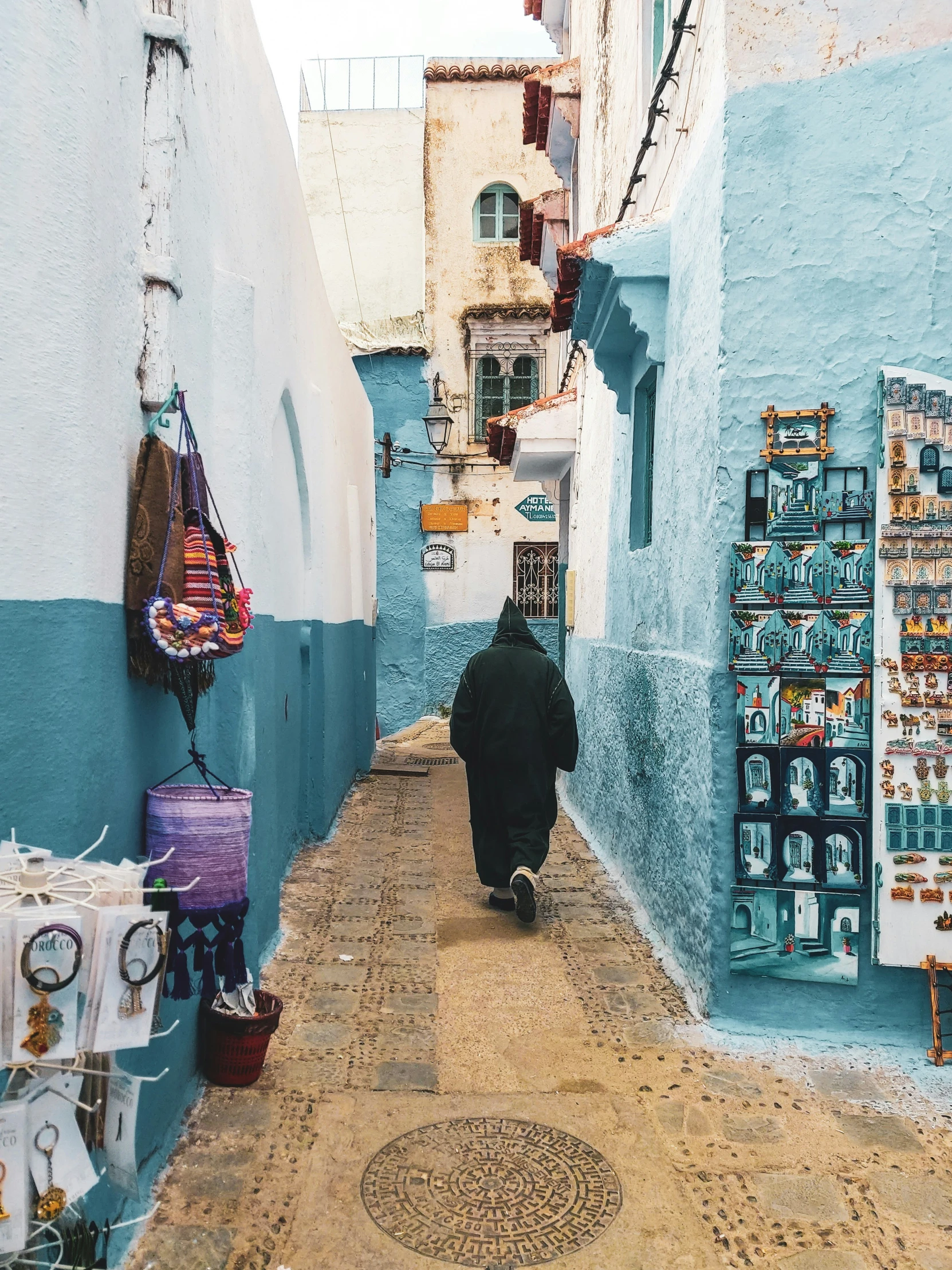 the man is walking down the narrow alleyway