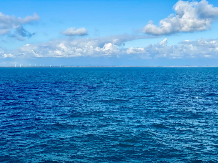 a large body of blue water next to a pier