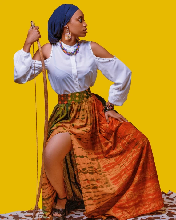 a woman is posing in front of a bright yellow backdrop