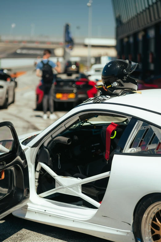 a car with its doors open is parked by a police officer