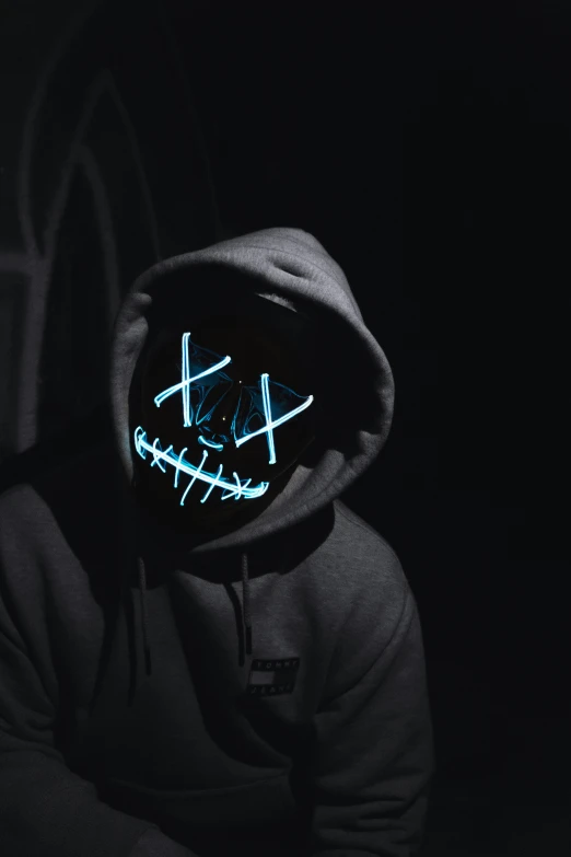 a person wearing a hooded hoodie with neon lights