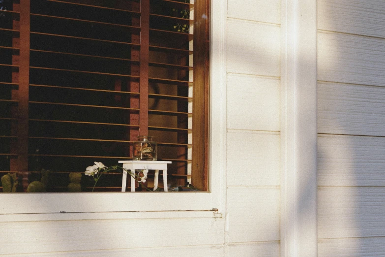 a white chair sits on the porch with some windows