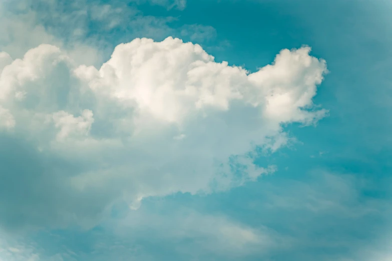 a plane flying above the clouds under blue skies