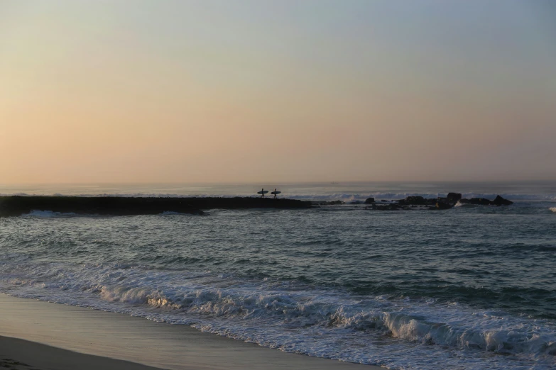 the water waves near the shore and some people on them