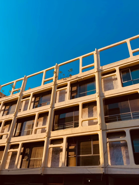 a tall building with several balconies and bars on the top floor