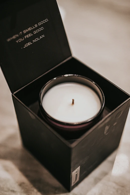 a black box is holding an apple candle