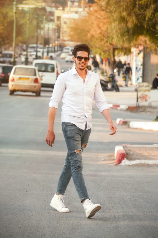 a man in jeans walking down the street