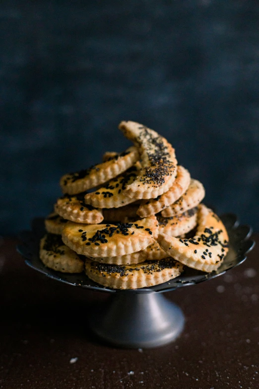 a plate filled with cookies with black sprinkles on top