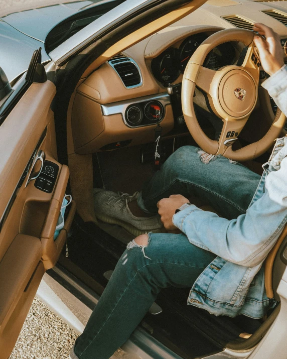 a man sitting in the front seat of a car while holding the steering wheel