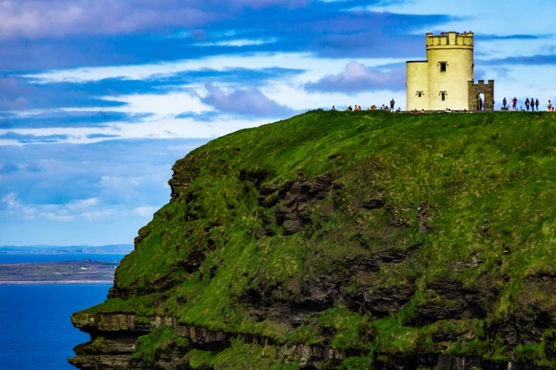 a small light house on top of a hill above the water