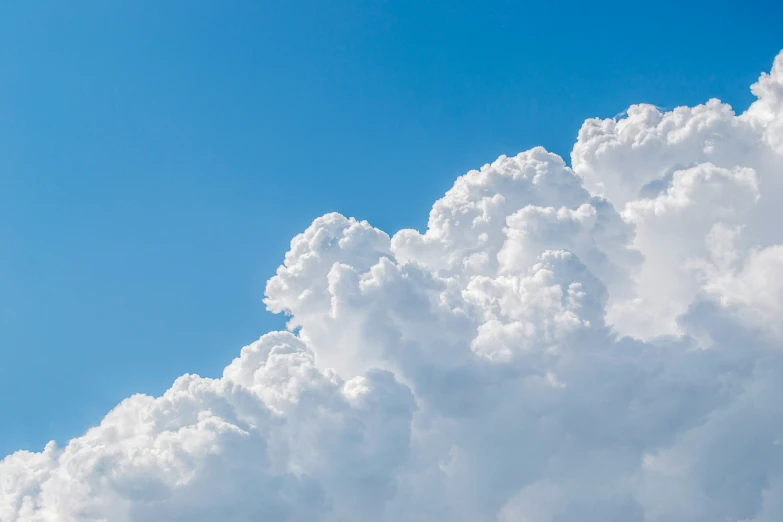 an airplane flying away under a huge cloud