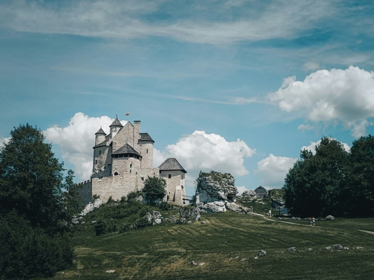 a tall castle on top of a green hill