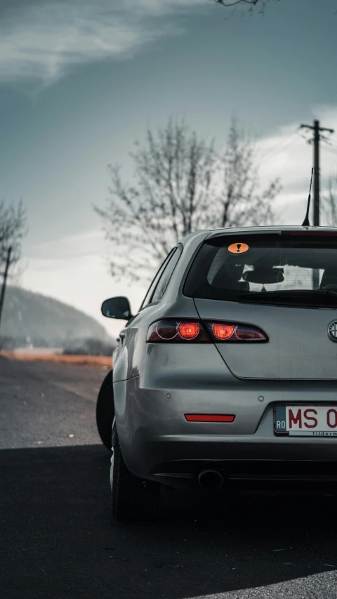 a grey car with yellow lights is parked in the street