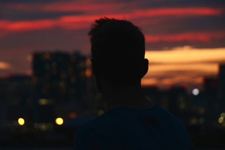 a man watching a sunset in the city