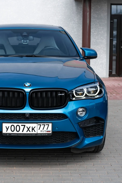 a bright blue sports car parked in front of a white building