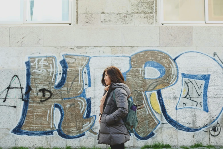 woman looking at wall with graffitti that says graffiti