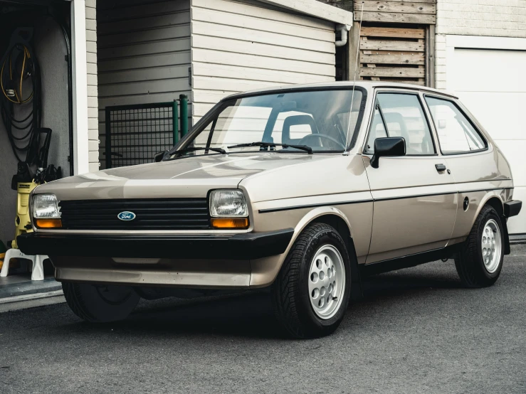 an old beige car is parked next to the garage