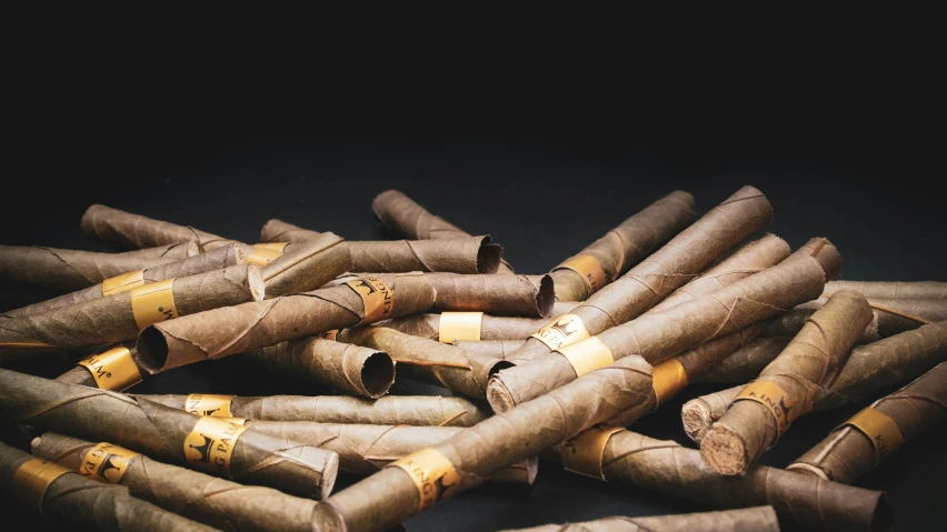 several pairs of cigars are piled on top of each other
