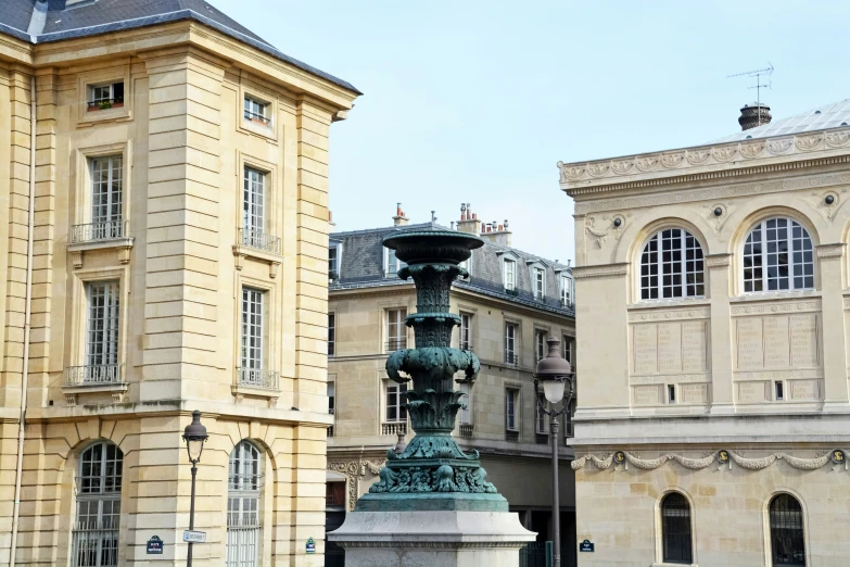 a water fountain in the middle of a courtyard with two buildings