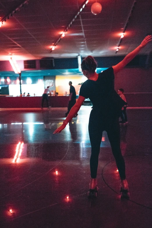 young person practicing at a dance studio in a dimly lit room