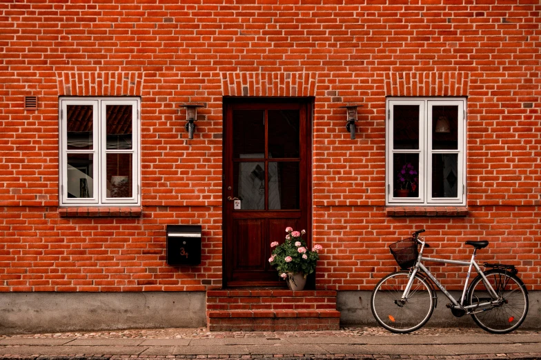 a bicycle is parked in front of a brick building