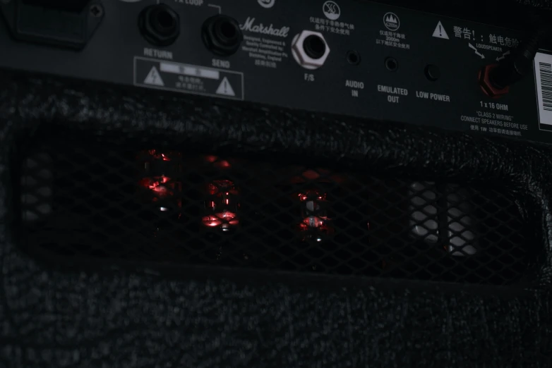 the back of a black amplifier with the s glowing red