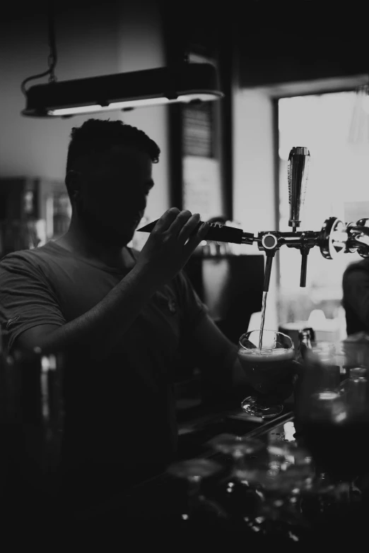 a man mixing soing in a glass on top of a table