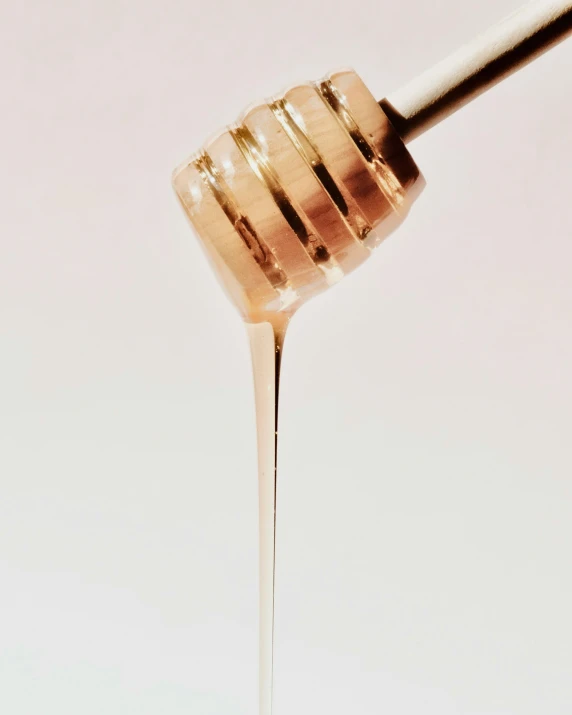 a honey dripping out of a spoon